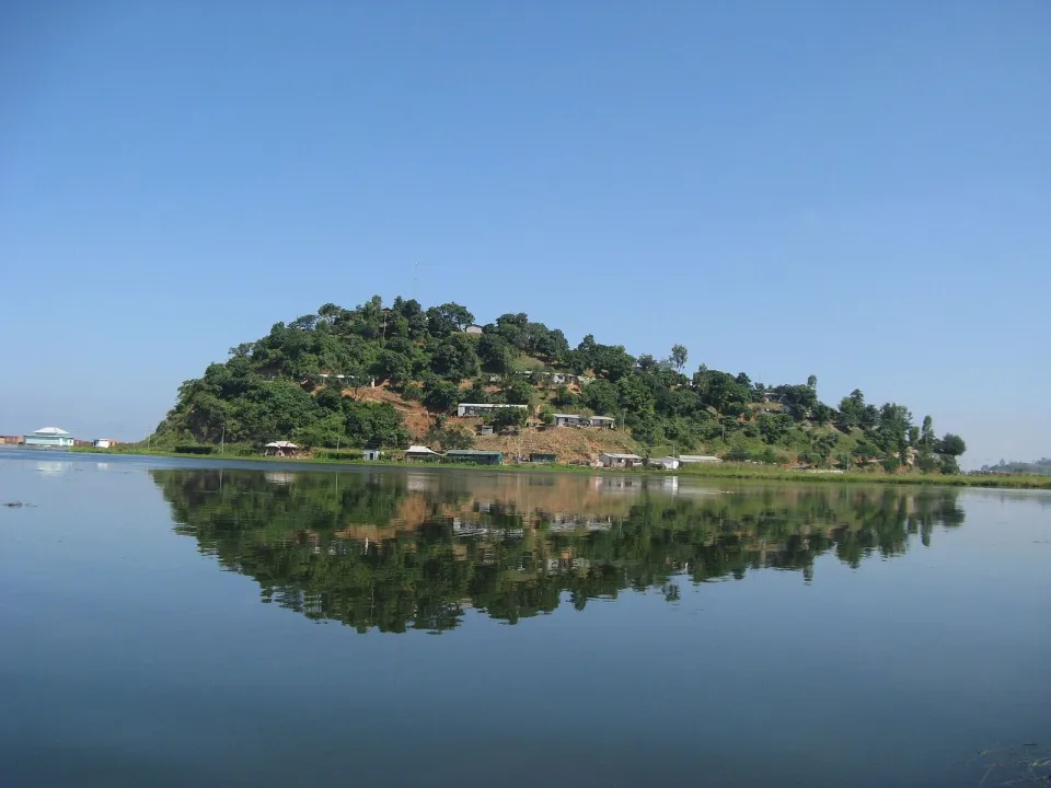 A wooded island mirrored in the still water of Loktak Lake in Manipur